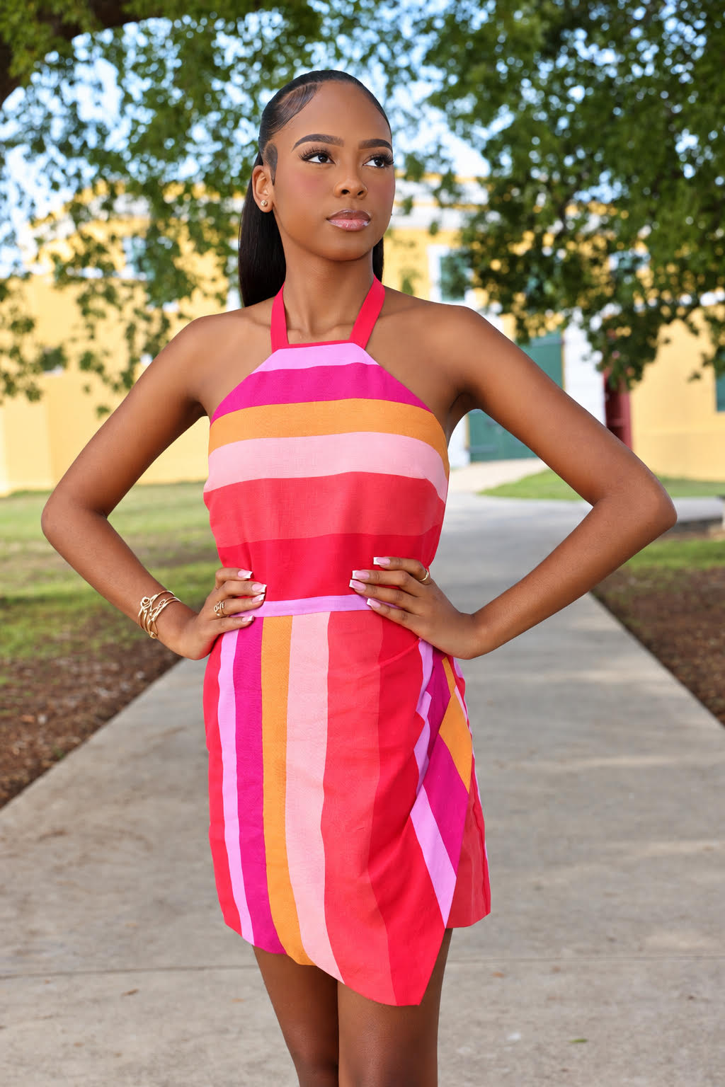 Karis Jordan in a vibrant striped dress beneath the trees